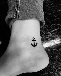 an anchor tattoo on the ankle is shown in this black and white photo, it looks like