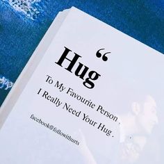 a white book with the words hug on it sitting on top of a blue blanket