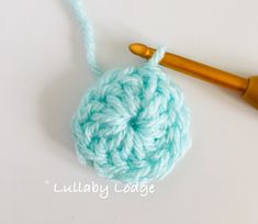 the crochet ball is being worked on by a knitting needle with a wooden handle