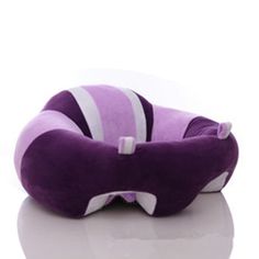 a purple and white pillow sitting on top of a table