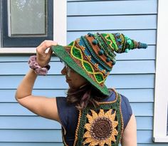 a woman wearing a crocheted sunflower hat