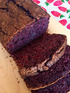 a loaf of chocolate cake sitting on top of a wooden cutting board