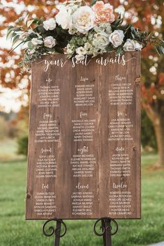 a wooden sign with flowers and greenery on it that says your seat awaits