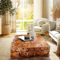 a living room with a couch, chair and coffee table in front of a window