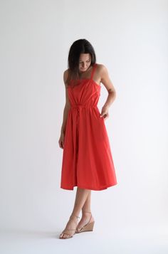 Manuelle Guibal Sundress in color Red Rock Lightweight, tea length with adjustable cinch tie closure at waist. Features straps with adjustable ties at back and pockets at hips. 100% cotton, Made in France Cotton Midi Dress With Adjustable Straps, Cotton Midi Dress With Adjustable Spaghetti Straps, Red Midi Dress With Adjustable Straps, Red Cotton Midi Dress For Daywear, Spring Red Midi Dress With Pockets, Cotton Midi Dress With Tie Back And Spaghetti Straps, Cotton Midi Dress With Spaghetti Straps And Tie Back, Casual Red Dress With Tie Straps, Casual Red Dresses With Tie Straps