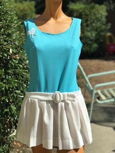 Here is a vintage 1970s tennis dress.Following are the measurements. Bust 36",waist 32",Hips full with pleats,length 29".Made out of polyester fabric .Bodice is a solid stripe turquoise fabric. Skirt has pleats with a belt.In nice vintage condition. Please take special consideration of measurements. 1970s sizing was very small to today's standards. Tennis dresses were very short not like a regular dress. So please take special note of length. If you live overseas please email me first before purchasing for mailing cost. Price quoted is for USA only Vintage Tennis Dress, Summer Pleated Tennis Dress, Pleated Tennis Dress For Summer, Summer Tennis Dress With Pleated Skirt, Retro Summer Dress With Pleated Skirt, Spring Fitted Blue Tennis Dress, Fitted Blue Spring Tennis Dress, Fitted Blue Tennis Dress For Spring, Vintage Pleated Summer Dress