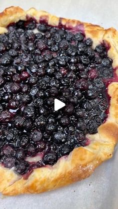 a pie with blueberries on it sitting on top of a table