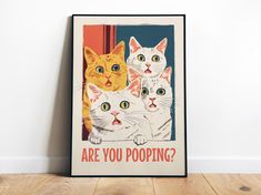 a poster with three cats on it that says are you pooping? in front of a white wall