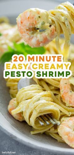 pasta with shrimp and pesto is being lifted from a fork over the top of it