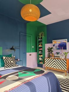 a bed room with a neatly made bed and colorful walls