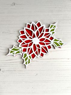 a red and green flower cut out from paper