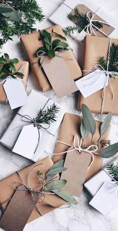 christmas presents wrapped in brown paper and tied with twine, greenery and tags