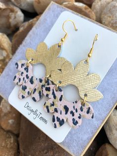 the leopard print dangle earrings are in gold and pink, with black spots on them