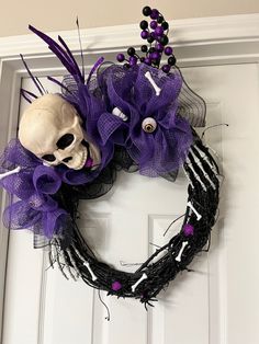 a wreath with a skull and purple flowers