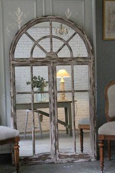 an old arched window is shown in this room with two chairs and a small table