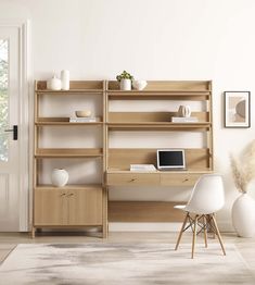 a room with a desk, chair and computer on the shelf next to an open door