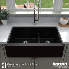 a double black kitchen sink in front of a window with the words quatz apron front sink