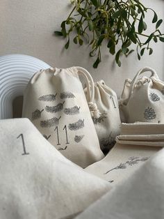 three bags sitting on top of a table next to a plant