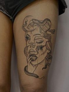 a woman's thigh with tattoos on her legs and an image of a snake