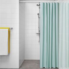 a bathroom with a shower curtain and white tile walls