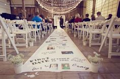 the aisle is lined with white chairs and decorated with flowers, photos, and pictures