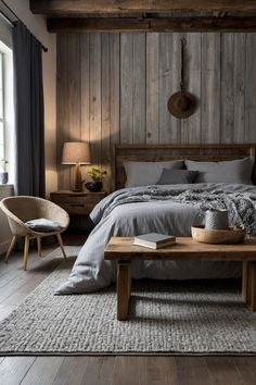 a bedroom with wood paneling and gray bedding, two chairs and a coffee table