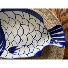 a blue and white fish dish sitting on top of a rug