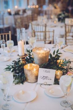 the table is set with candles and place cards