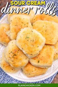 a white plate topped with dumplings on top of a blue cloth and text overlay reads sour cream dinner rolls