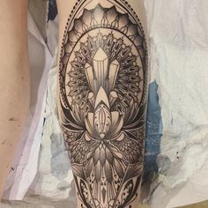 a woman's leg with an intricate tattoo design on the side of her thigh