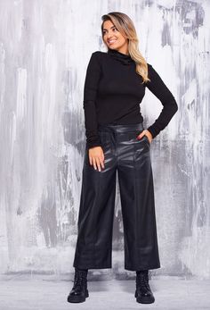 "These faux leather pants are a true symbol of elegance and retro style, inspired by the unique era of the 90s. Its calf-length length lends a casual yet impactful charm. The front zip fastening and hidden button ensure a perfect fit and accentuate the contours of the body. The front pockets add practicality, while the masterfully recreated back pockets are an elegant imitation with subtle detailing on the fillets. The slightly flared legs with the front decorative seam give the trousers character and uniqueness. Made of supple and soft synthetic leather, it provides all-day comfort and freedom of movement. The possibility to choose from several colors makes it a universal choice for any fashion combination. This pant is a true symbol of aesthetics and style that brings to life the spirit Caprese Pants Outfits, Cropped Faux Leather Pants Outfit, Fall Wide Leg Faux Leather Pants, Elegant Faux Leather Wide Leg Pants, Elegant Wide Leg Faux Leather Pants, Fall Faux Leather Wide-leg Pants, Wide-leg Leather Pants For Work In Fall, Elegant Faux Leather Trousers, Chic Faux Leather Wide Leg Pants