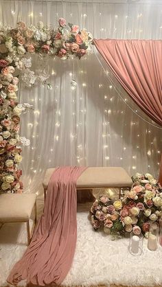 a wedding ceremony setup with flowers on the stage and draping over the top