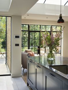 a kitchen with an island and glass doors leading to the outside patio area is shown