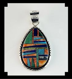 "This beautiful inlay pendant has been inlaid with a number of different stones giving it a wonderful array of color. The artist used two different colors of turquoise, spiny oyster, lapis, gaspeite, malachite and seraphinite also known as angels wing. The large verity of stones have been inlaid in geometric pattern and finished with a rolled notched edge.    The pendant can be purchase alone or with the leather collar. The gemstone necklaces are sold separately.  Specifics: Metal: Sterling Stone: Turquoise, Spiny Oyster, Lapis Lazuli, Gaspeite, Malachite and Seraphinite.  Size of Pendant: 2 3/8\" by 1 1/2\" not counting the bail or 2 ¾ \" with the bail. Weight of Pendant: 26.4 grams Signed: TS Colorful Necklace:  https://www.etsy.com/listing/1656479327/white-fox-creation-chunky-turquoise- Multicolor Oval Stone Jewelry, Multicolor Round Cabochon Gemstones, Unique Multicolor Oval Gemstones, Multicolor Round Collectible Jewelry, Artisan Multicolor Pendant Jewelry, Unique Oval Inlay Jewelry, Multicolor Cabochon Gemstones, Unique Oval Jewelry With Inlay, Teardrop Multicolor Gemstones For Jewelry Making