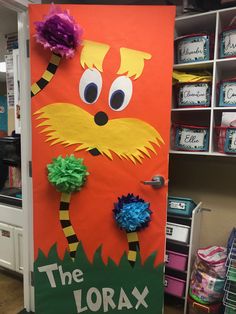 the lorax door is decorated with tissue pom poms and paper flowers