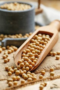 a wooden spoon filled with chickpeas on top of a table