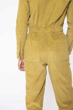 the back view of a man wearing a tan jumpsuit