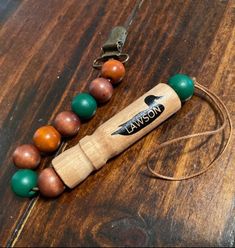 a wooden bead necklace with a bottle opener on it and a keychain