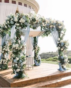 an outdoor ceremony setup with flowers and greenery