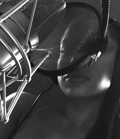 a black and white photo of headphones on top of a radio microphone in front of a woman's face