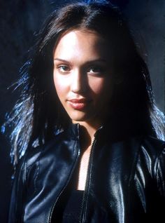 a close up of a person wearing a black leather jacket and posing for a photo