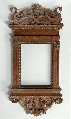 an old wooden frame with carvings on the front and sides, hanging on a wall