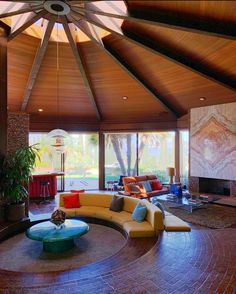 a living room filled with lots of furniture and a fire place in the middle of it