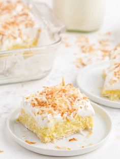 a piece of cake on a plate next to a glass container with milk in it