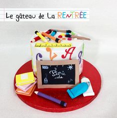 a birthday cake with chalkboard and crayons on the top is decorated like a teacher's desk