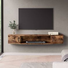 a flat screen tv mounted to the side of a wooden entertainment center in a living room