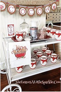 a table topped with lots of cups and saucers on top of a metal shelf