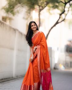 a woman in an orange and pink sari