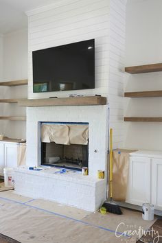 the fireplace is being built and ready to be installed in the living room with shelves on either side