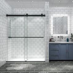 a white tiled bathroom with blue cabinets and gray counter tops, along with a walk in shower